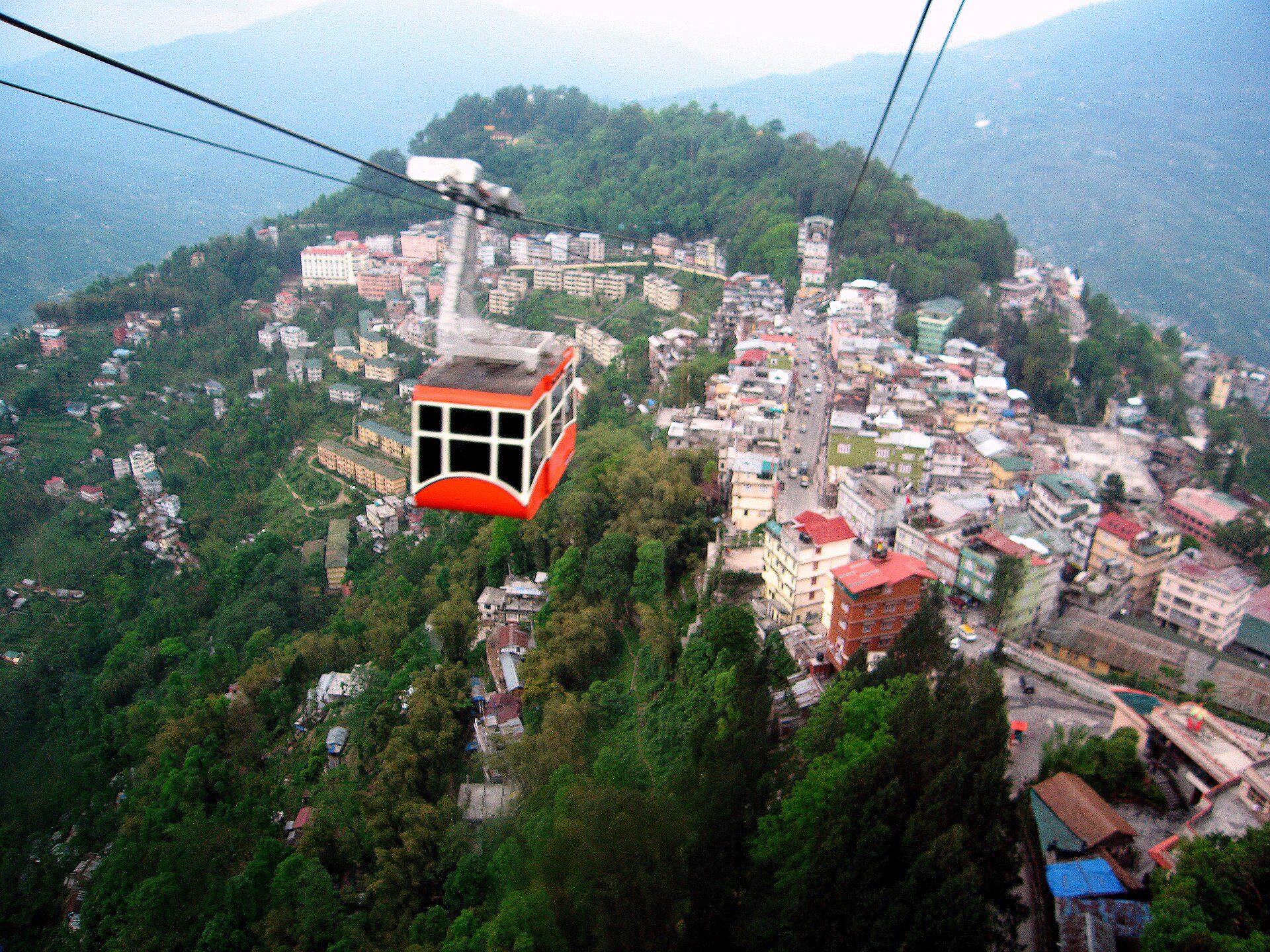 Aerial cable car of the Gangtok Ropeway suspended above the terraced hillside neighborhoods of Gangtok, Sikkim