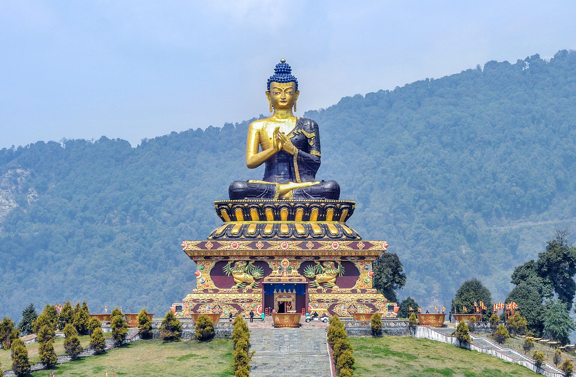 Towering golden statue of Lord Buddha at Tathagata Tsal (Buddha Park) in Ravangla set against green South Sikkim hills