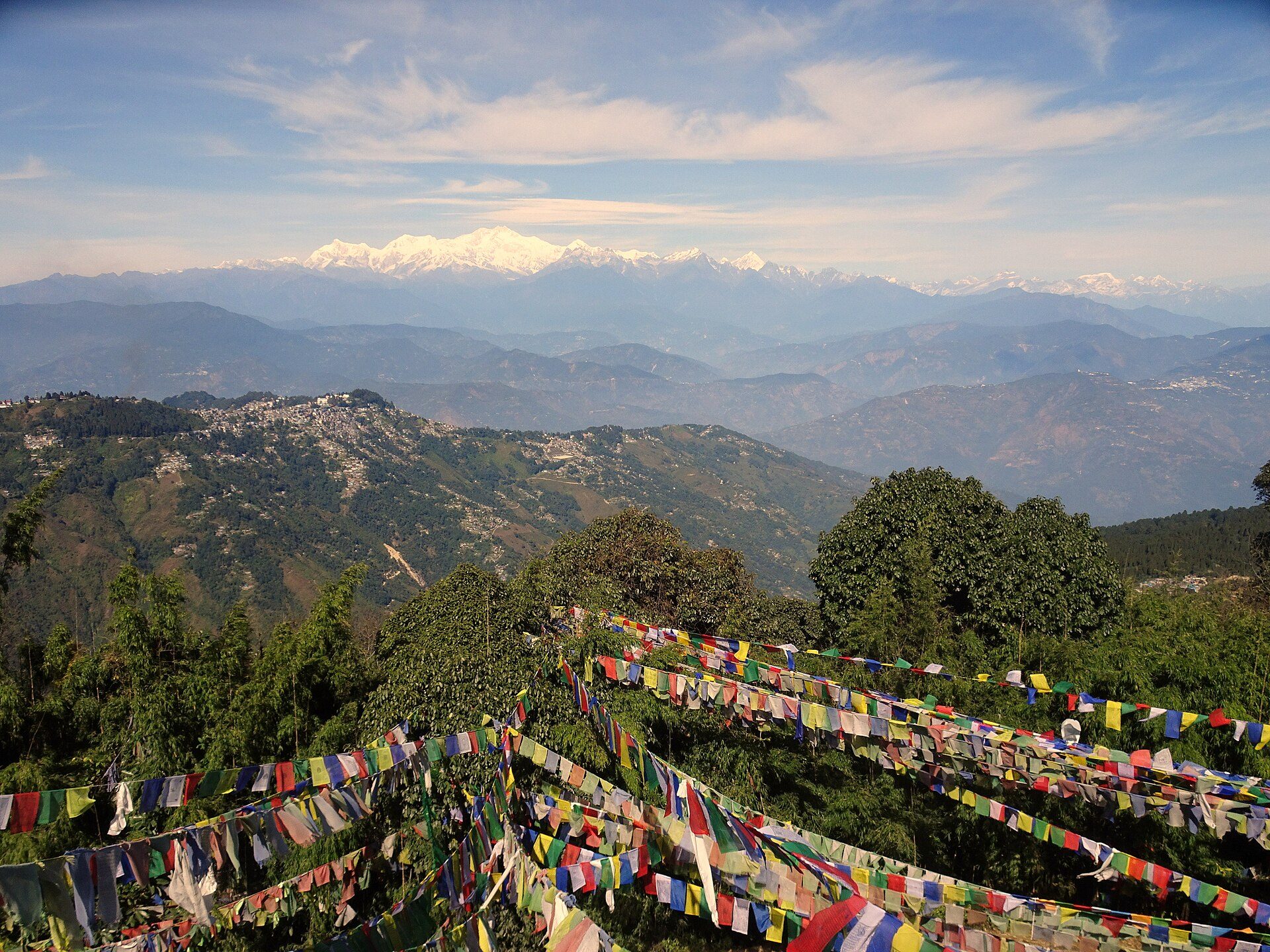 Panoramic view of the snow-clad Kangchenjunga range from Tiger Hill with colorful prayer flags in the foreground